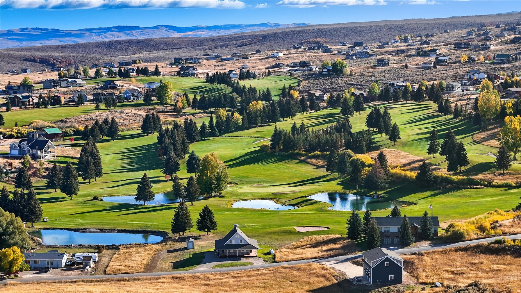 Bear Lake Golf Course fairways and water features framed by mountain homes