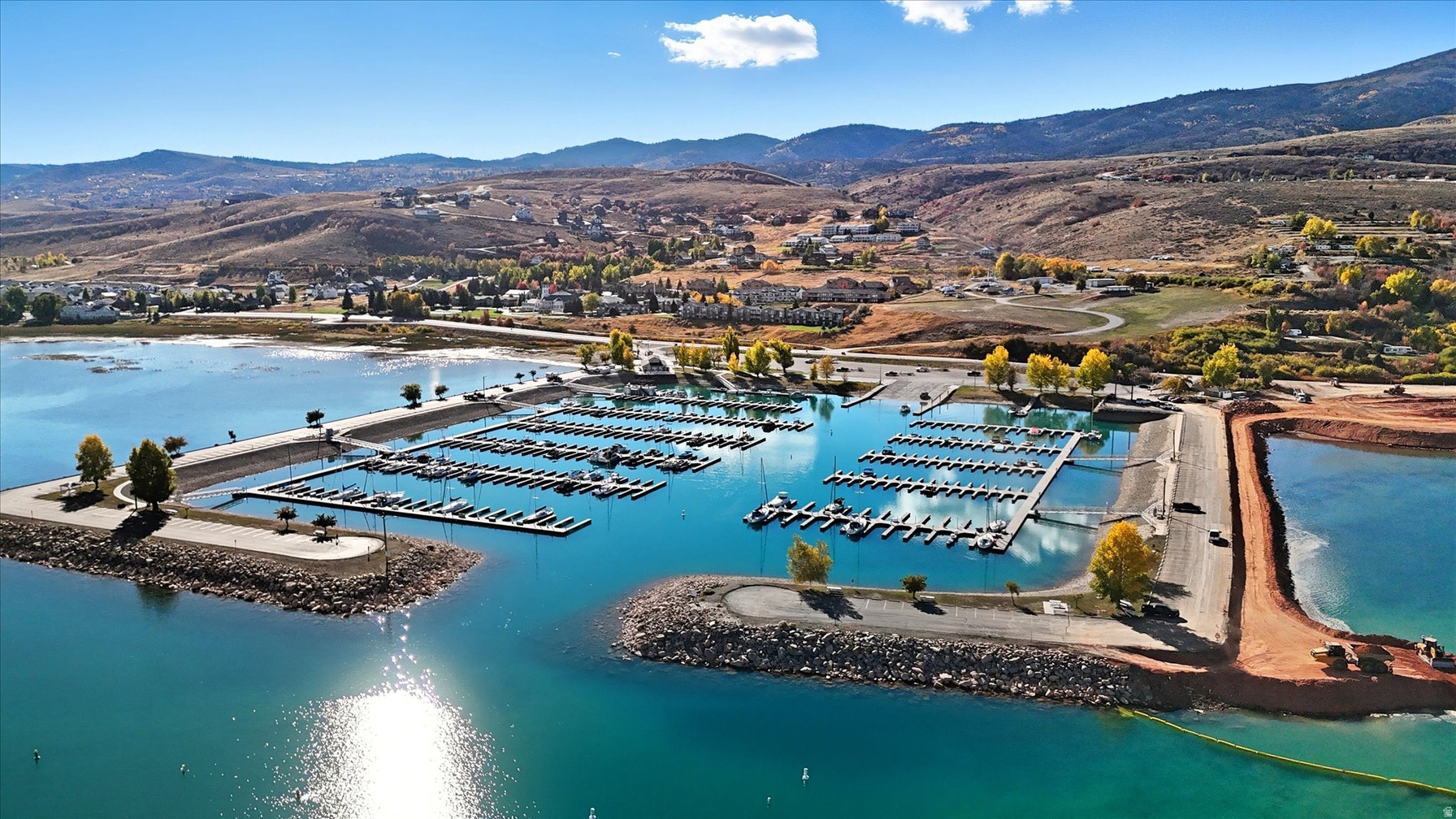 Bear Lake State Park Marina full of boats with mountains behind on a clear blue day