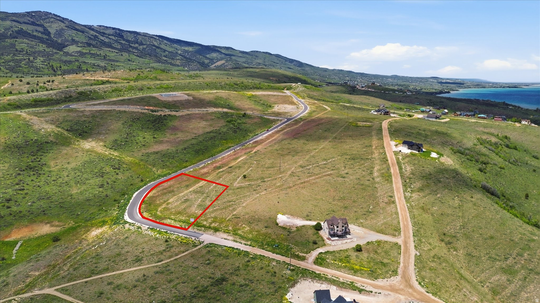 Lot 65 cul-de-sac homesite outlined in red with rolling green mountains and Bear Lake to the east